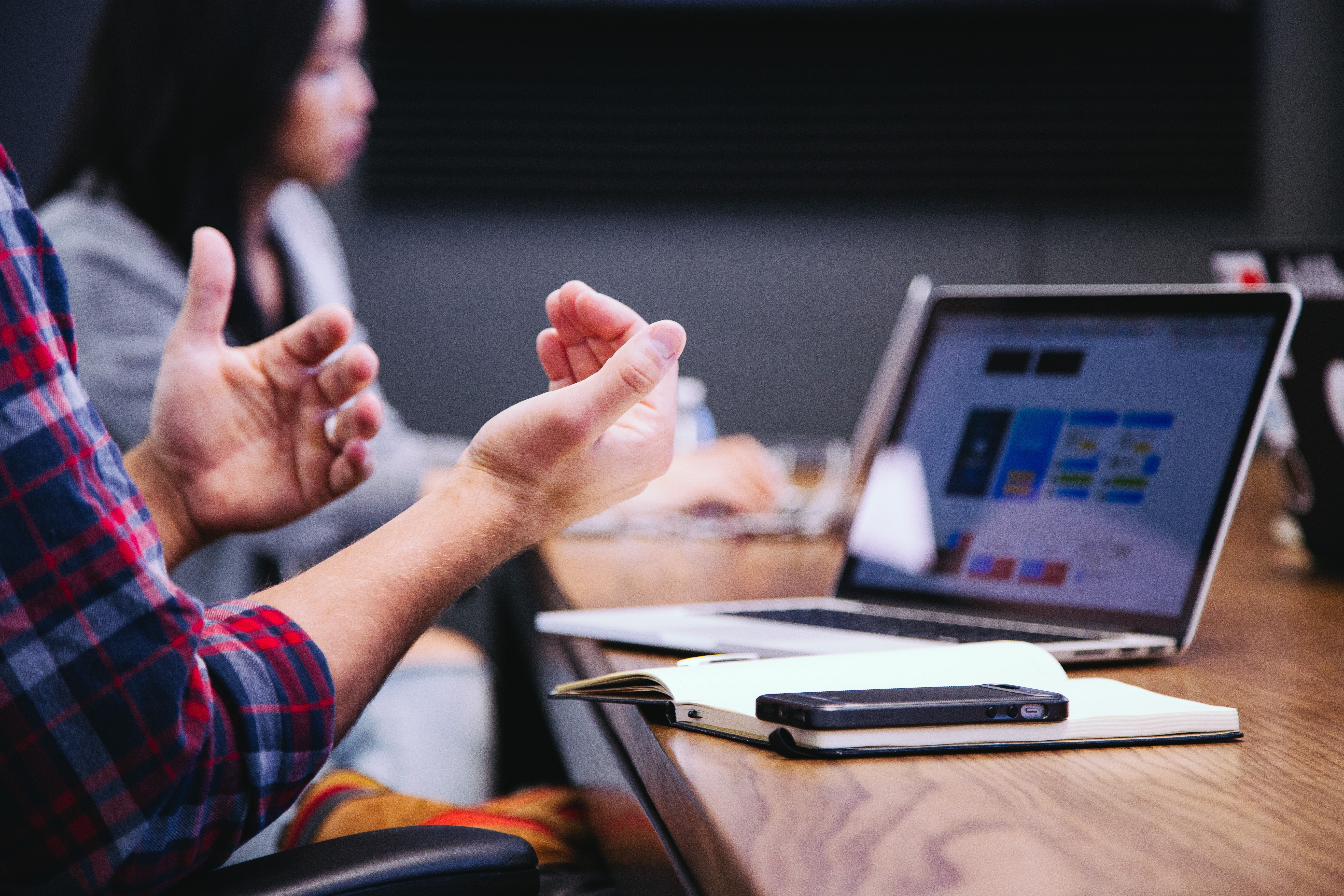 Image of person's hands out in front of them with a laptop in the foreground.