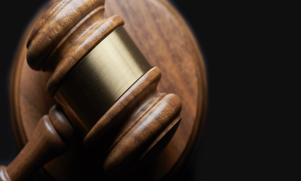 Image of a gavel resting on top of a circular piece of wood.