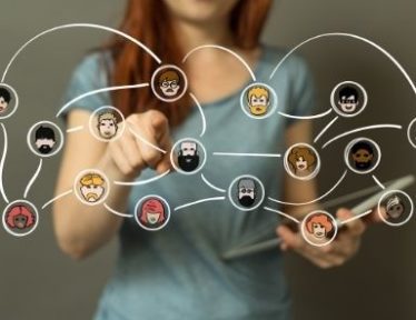 Image of a woman's finger pointing at a diagram of a network of connected people.